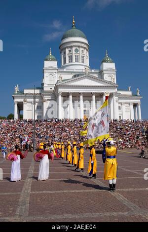 Vista su tutta la Piazza del Senato verso sud coreano banda militare e la gente seduta sui gradini della cattedrale luterana, Helsinki, Finlandia, Europa Foto Stock