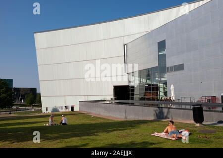 La gente seduta vicino alla piscina presso il Museo di arte moderna Kiasma a Helsinki in Finlandia e Scandinavia, Europa Foto Stock