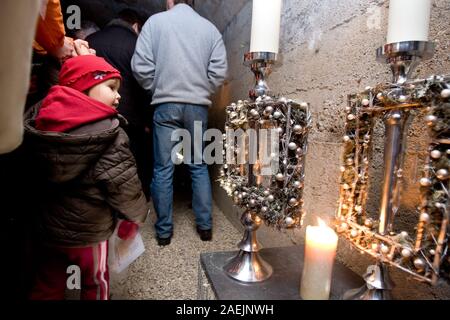 Kranj, Slovenia, Novembre 23, 2008: i visitatori passano ghirlande sul display a una mostra nel vecchio tunnel sotterranei. Foto Stock