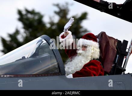 Santa Claus onde per i membri del servizio e le loro famiglie come egli arriva in un'U.S. Air Force F-15E Strike Eagle jet da combattimento a Royal Air Force Lakenheath Dicembre 7, 2019 in Lakenheath, Inghilterra. Foto Stock