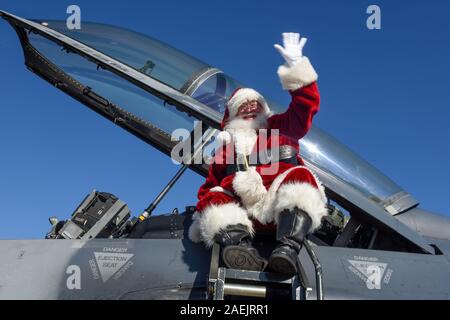 Santa Claus onde per i membri del servizio e le loro famiglie come egli arriva in un'U.S. Air Force F-16 Fighting Falcon jet da combattimento a McEntire congiunta nazionale di base di guardia Dicembre 7, 2019 in Hopkins, Carolina del Sud. Foto Stock