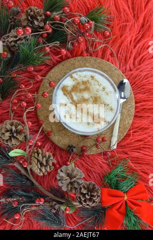 Budino di riso e artificiale rami sempreverdi su rosso lungo rug Foto Stock