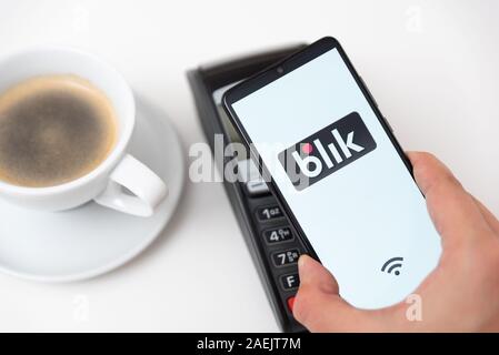 Wroclaw, Polonia - Nov 06, 2019: uomo tenendo lo smartphone con il logo Blik, il pagamento senza contatto. Blik è polacco più popolari di pagamento rapido metodo in Polonia Foto Stock