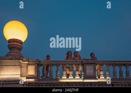 Guilin, Cina - Agosto 2019 : madre con i suoi figli guardando giù dal ponte stradale sull'estuario del Rong Shan e laghi di notte, Guilin tow Foto Stock