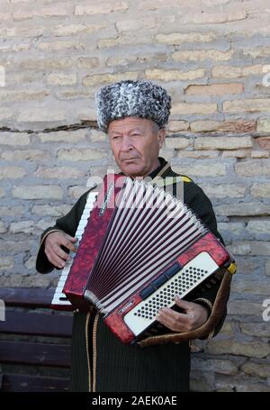 Street performer di Khiva suonando la fisarmonica Foto Stock