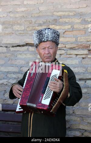 Street performer di Khiva suonando la fisarmonica Foto Stock