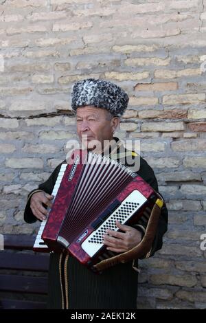 Street performer di Khiva suonando la fisarmonica Foto Stock