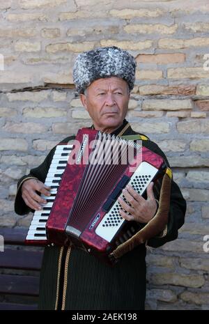 Street performer di Khiva suonando la fisarmonica Foto Stock