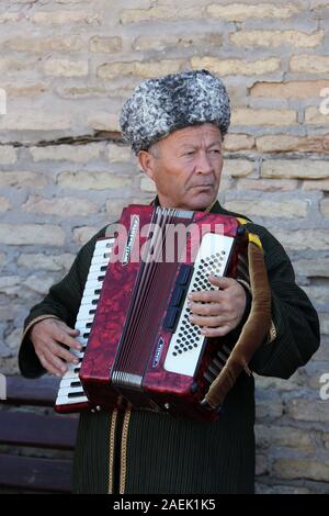 Street performer di Khiva suonando la fisarmonica Foto Stock