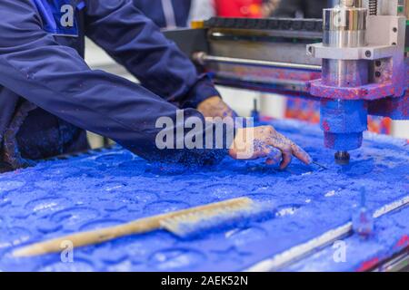 Macchina fresatrice durante il lavoro con blu di materiale plastico in corrispondenza di technology trade show Foto Stock