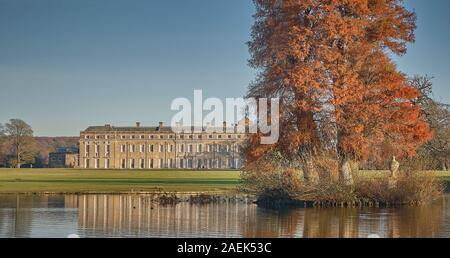 Petworth House e il lago con golden autumn alberi Foto Stock