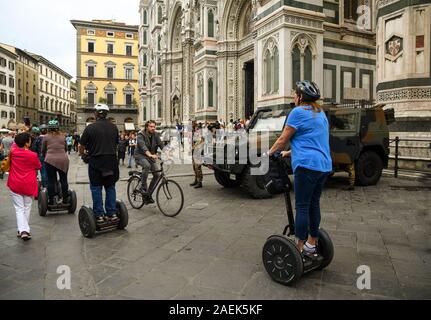 Gruppo di turisti avente city tour a bordo di Segway scooter elettrici nella parte anteriore della Cattedrale di Santa Maria del Fiore, Unesco W.H. Sito, Toscana, Italia Foto Stock