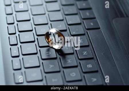 STARGATE: un anello d'oro viene visualizzato sulla tastiera di un computer portatile. Foto Stock