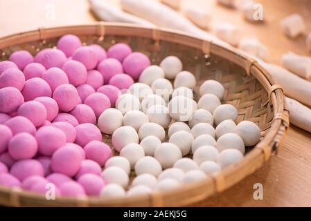 Una donna in Asia è rendere Tang yuan yuan xiao, cinese tradizionale cibo Gnocchi di riso in bianco e rosso per il nuovo anno lunare, festival invernale, vicino. Foto Stock