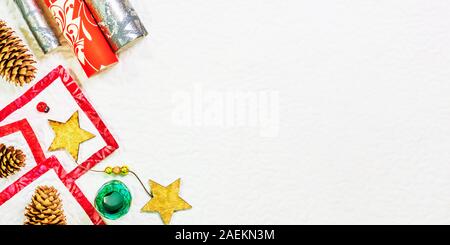 Vacanze invernali ampia piana composizione laici con copia spazio sulla destra. Vista dall'alto in basso della confezione regalo carta abete, coni, stelle e nastro verde. Foto Stock