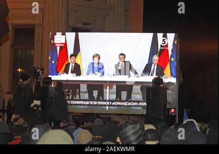 Kiev, Ucraina. Decimo Dec, 2019. Manifestanti ucraini guarda una schermata visualizzata da una conferenza stampa del leader della Normandia quattro, durante una manifestazione davanti il presidente ucraino ufficio a Kiev, Ucraina, il 10 dicembre 2019. Gli ucraini riuniti presso il presidente ucraino ufficio da notte Dicembre 08, per ottenere la Normandia formato risultati della riunione che si è tenuta a Parigi il 10 dicembre, 2019. Credito: Serg Glovny/ZUMA filo/Alamy Live News Foto Stock