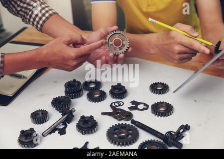 Ingegnere discutendo e progettazione circa la marcia meccanica parti in ufficio. Foto Stock