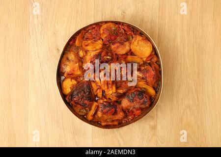 patate con pollo e verdure su un vassoio da forno su un tavolo di legno Foto Stock