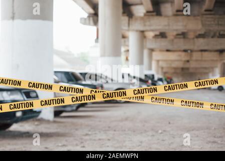 Vietato il territorio. Spia gialla di attenzione nastro in prossimità del parcheggio auto al giorno. Scena del crimine Foto Stock