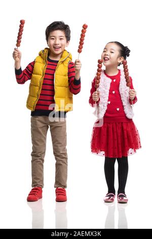 Dei bambini felici di mangiare haws candita Foto Stock