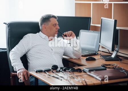 Guardando gli schemi. Poligrafo esaminatore lavora in ufficio con il suo lie detector di apparecchiature Foto Stock