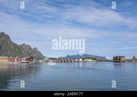 SVOLVAER NORVEGIA Luglio 07 2019: case tradizionali su enbakments presso il village harbour con ripide montagne sullo sfondo, girato sotto la luminosa luce estiva o Foto Stock