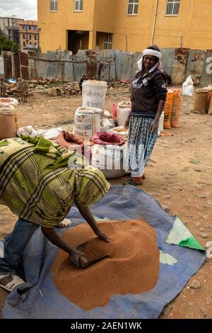 Etiopia, Amhara Region, sbarcare, centro città, area di mercato, uomo trasferimento tef il grano per fare injera nel sacco con convogliatore Foto Stock