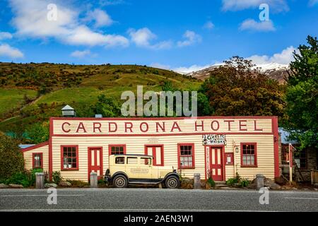 Basso angolo di visione dell'iconico Cardrona Hotel facciata, con la storica vettura nella parte anteriore di essa, Cardrona, South Island, in Nuova Zelanda. Foto Stock