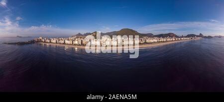 Piena vista aerea della spiaggia di Copacabana e di quartiere a precoce sunrise fiancheggiato dalla montagna di Sugarloaf sulla destra e il Forte di Copacabana sulla sinistra Foto Stock