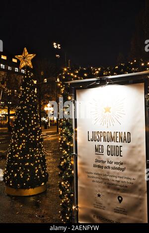 Illuminato albero di Natale e di inserzione in svedese per la passeggiata guidata di luce, Kungstradgarden, Norrmalm, Stoccolma, Svezia Foto Stock