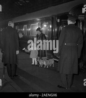 Come la Regina Elisabetta II prende la carica dei due corgis, il principe Andréj si scuote le mani con la stazione master a Liverpool Street Station di Londra. La regina aveva appena tornato a Londra con il principe da Sandringham, dove erano stati per le vacanze di Natale. Foto Stock