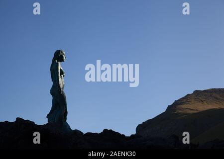 Mikladalur, Kalsoy, Isole Faroe - 20 Settembre 2019: la guarnizione donna un monumento al tramonto Foto Stock