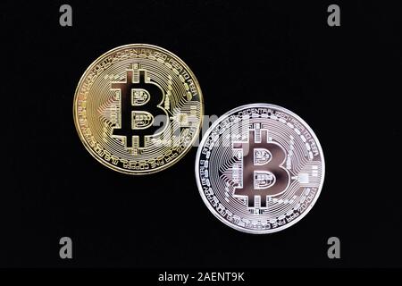 Argento e Oro bitcoins su sfondo nero. Bitcoin mining concetto. Un lucido due monete di cryptocurrency su sfondo scuro. Denaro virtuale Foto Stock