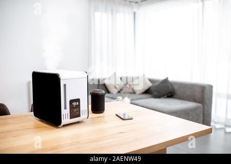 Funziona umidificatore d'aria sul tavolo del salotto. Home aria concetto di umidificazione Foto Stock