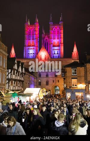 Cattedrale di Lincoln illuminata con luce colorata introdotto nel 2019. Foto scattata durante il mercatino di Natale guardando dal castello. Foto Stock