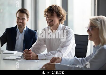 Personale gentile, colleghi divertendosi conversazione al briefing aziendale Foto Stock