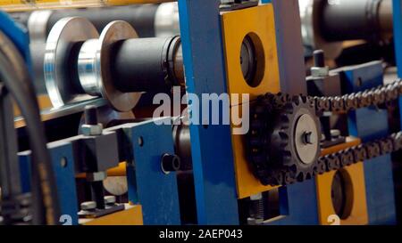 Acciaio industriale bobina bobina per il profilo metallico formante macchina in lamiera factory workshop. Ruote dentate in acciaio , cog set di ingranaggi di alta precisione e foglio di metallo Foto Stock