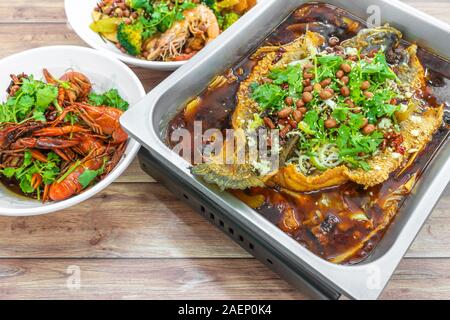 Sichuan grigliate di pesce in rosso piccante, olio e mini aragoste. Autentico cinese Cina Szechuan Chongqing il cibo sulla tavola. Foto Stock