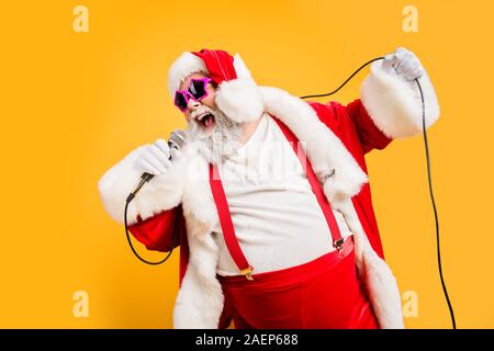 Merry X-mas canti natalizi da crazy sovrappeso pelo bianco Natale nonno tenere il microfono Sing canzone sul tempo di noel celebrazione di usura alla moda in stile Foto Stock