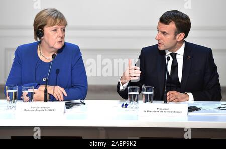 Parigi, Francia. 10 dicembre, 2019. Il Presidente francese Emmanuel Macron, destra, risponde a una domanda come il Cancelliere tedesco Angela Merkel guarda su nel corso di una conferenza stampa congiunta a seguito della conclusione del formato della Normandia riunione al vertice dell'Elysee Palace 10 Dicembre 2019 a Parigi, Francia. Credito: Alexei Nikolsky Cremlino/Piscina/Alamy Live News Foto Stock
