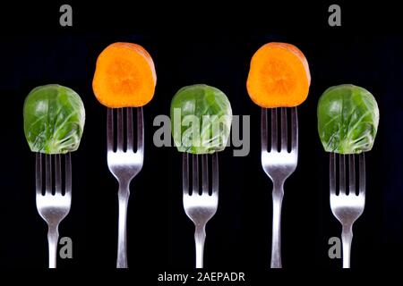 Le carote e i cavoletti di Bruxelles sulle forcelle. Mangiare e ottenere tutte le sostanze nutrienti! Foto Stock