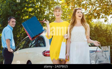 Le donne con le borse della spesa in uscita di taxi Foto Stock