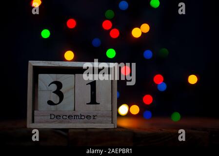 Cubo di legno che mostra calendario data 31 dicembre su sfondo bokeh di fondo. Felice anno nuovo 2020. Simbolo dal numero 31.12 Foto Stock