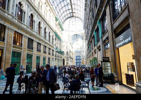 La gente seduta, mescolandosi, riuniranno, all'interno del ferro e del vetro, galleria shopping Galleria Umberto I di Napoli, Italia Foto Stock