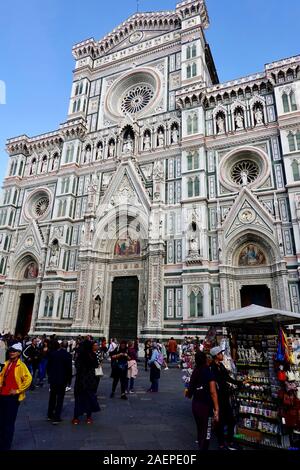 La folla di gente e venditori di souvenir di fronte al Duomo di Firenze, Cattedrale di Santa Maria del Fiore di Firenze (Italia). Foto Stock