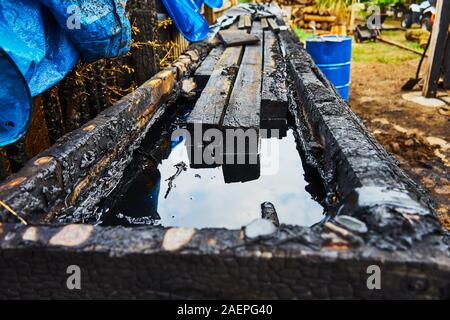 Un serbatoio riempito con olio vecchio per impregnazione di legno, inquinamento ambientale Foto Stock