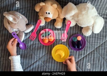 Bambino la sua alimentazione giocattoli imbottiti in casa. Giochi per bambini a casa. Foto Stock