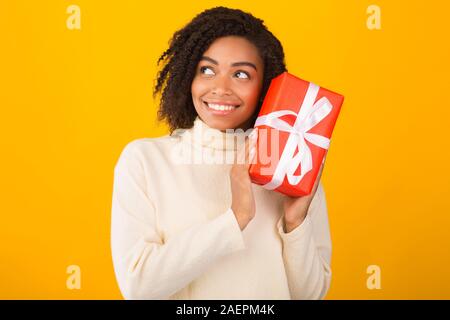 Sorridente americano africano donna scuotendo anno nuovo dono Foto Stock