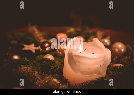 Illuminazione della candela sulla corona di Avvento durante il tempo di Natale Foto Stock