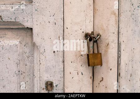 Il vecchio blocco di metallo su un bianco porta in legno Foto Stock